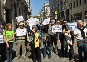 Foto: Un grupo de personas con carteles en rechazo a los códigos de Edificación y Urbanístico en la Ciudad de Buenos Aires, en ella Silvia Coriat habla a através de un megáfono.